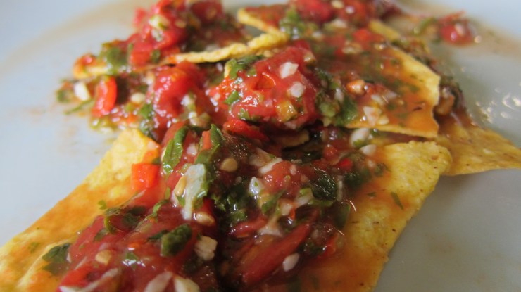 red hot salsa on corn chips by tiny chili pepper